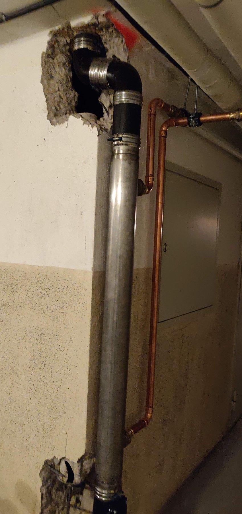 Ingjuten avloppsstam som har bilats fram och ersatts med en utanpåliggande spillvattenvärmeväxlare.